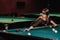 A girl with a blindfold and a cue in her hands in a billiard club.Russian billiards