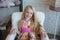 Girl blonde with long hair sitting in a chair and smiling, decoration, decor, lifestyle, family, family values