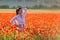 Girl at blooming poppy field