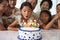 Girl Blows Out Candles At Family Birthday Celebration