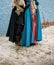 A girl in a blue cloak and a man in ancient clothes, uniforms, protection. stand near the river, hugs, couple, attitude