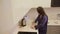 Girl in blue clothes with long hair brunette prepares fried eggs with sausages in the apartment kitchen