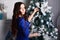 Girl in a blue dress decorates a Christmas tree