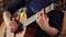 A girl in a blue dress is playing an acoustic guitar. Close-up. Hands on the strings of a musical instrument. Defocus at the end o