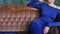 Girl in blue long dress lying on an old couch