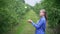 A girl in a blue shirt in an apple orchard juggles apples