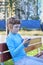 Girl in blue sits with smartphone on bench