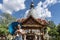 Girl with a blue umbrella in her hands with a comfortable expression sunbathing in front of a Buddhist temple