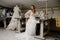 A girl in a boho wedding dress in a sewing workshop