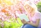 Girl with Book. Blonde Young Woman and Cherry Blossom