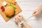 A girl with bound hands measuring tape, In front of a hamburger lying on a table.male hands holding a measuring tape without