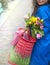 Girl with a bouquet of spring tulips in pink. In a blue raincoat and yellow boots on the street in Europe. Happy woman. Smile on