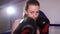 Girl boxer hits the camera with gloves. Boxing training.