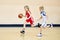 Girl and boy athlete in uniform playing basketball