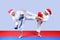 Girl and boy in a cap of Santa Claus are beating leg blows karate