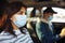 A girl and a boy driving in a car during coronavirus quarantine wearing medical masks. Safe taxi and healthcare during pandemic