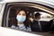 A girl and a boy driving in a car during coronavirus quarantine wearing medical masks. Safe taxi and healthcare during pandemic