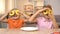 Girl and boy holding yellow donuts front of eyes, having fun, unhealthy snack