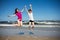 Girl and boy jumping on beach