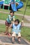 Girl & boy at the park swinging on sunny day