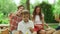 Girl and boy playing with soap bubbles in park. Family having picnic in forest