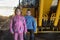 Girl and boy standing near crawler tractor