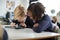 A girl and a boy using a tablet computer and stylus in a primary school class looking closely at the screen