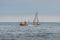 Girl and boys ride on a rubber inflatable boat on the sea. Boys learn to drive a small boat with a sail. Dinghy Sailing