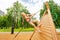 Girl with braids climbs on wooden construction