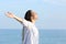 Girl breathing fresh air on the beach outstretching arms