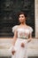 Girl-bride wedding dress with a beautiful floral pattern in Florence, stylish bride in a wedding dress stands in the Old city of