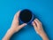 A girl with a bright blue coffee mug in her hands on a blue background