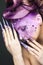 Girl with bright purple creative makeup with crystals and long nails. Beauty face.