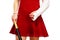 Girl with a broken arm in plaster, dressed for a party, wearing red dress, holding baseball bat