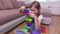 Girl builds a high tower from toy bricks