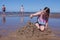 Girl is bulding sandcastles on the beach