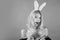 Girl with bunny ears holding Easter egg, copy space. Funny expression. Bunny rabbit. Fashion portrait of beautiful