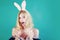 Girl with bunny ears holding Easter egg, copy space. Funny expression. Bunny rabbit. Fashion portrait of beautiful