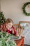 Girl burgundy dress decorates Christmas rustic room