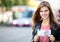 Girl at bus stop holding 50 euro