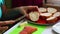 The girl is buttering a loaf for sandwiches with salmon. Close-up on a white background.