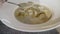 The girl in the cafe`s at the soup. Close-up of soup plates and spoons. In the visible soup croutons of bread. Beautiful first cou