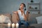 Girl Calling Electrician Service Sitting On Couch In Dark Room