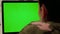 Girl in camouflage clothes makes video call on laptop with green screen