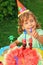 Girl in cap eats fruit in garden,happy birthday