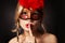 Girl with carnival mask. woman with finger on her red lips showing hush