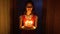 Girl carries the birthday cake with candles from the darkness