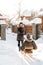 Girl carries a guy on a sled on a snowy street