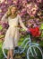 Girl carry flowers in retro bicycle. spring beautiful woman in dress. girl vintage bike. blooming sakura tree. summer