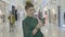 Girl carrying shopping bags while holding smartphone in her hand to video call live stream her best friend from the mall -